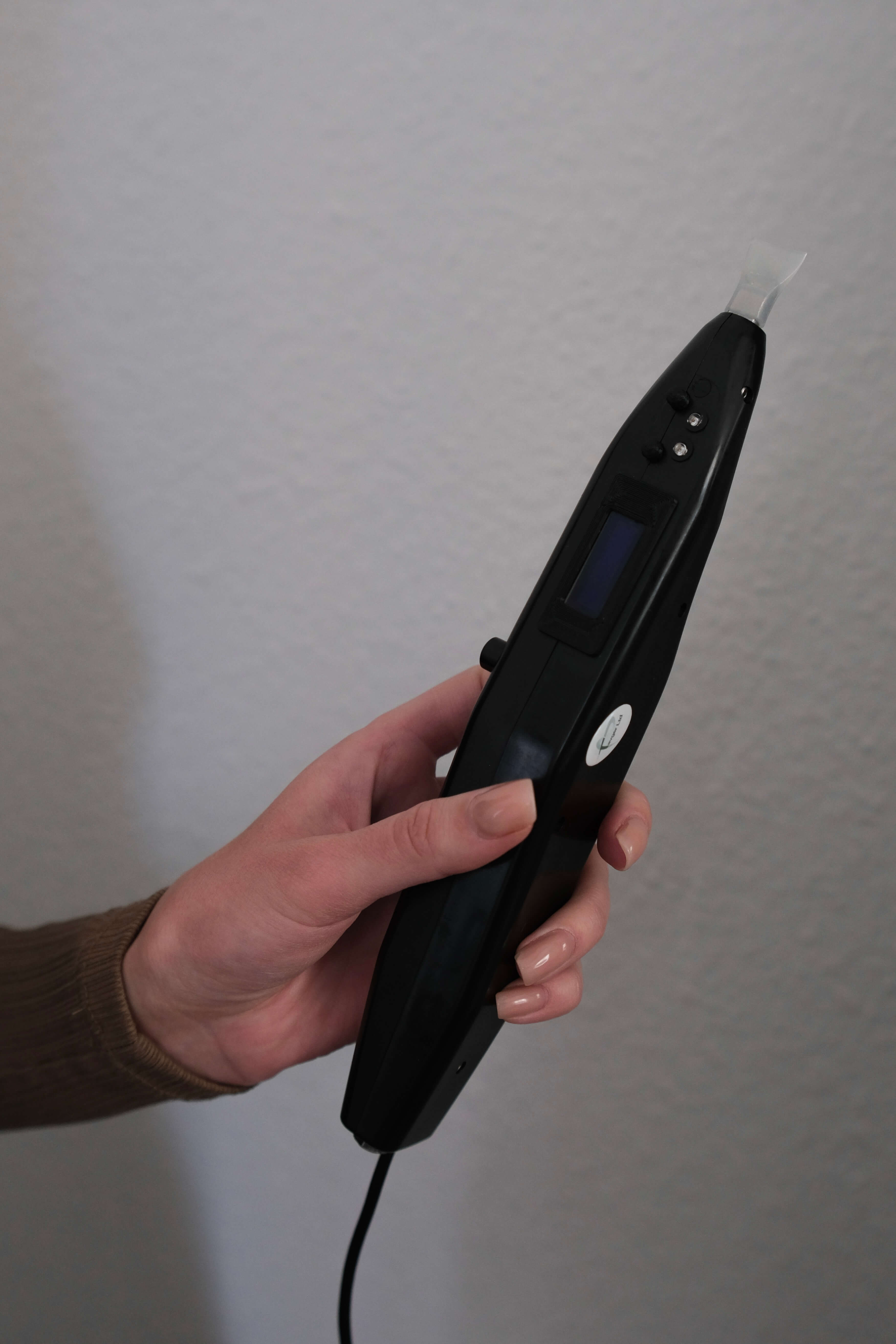 Kosmetikerin führt eine Behandlung mit dem BioRef-DC Gerät auf der Haut des Patienten durch